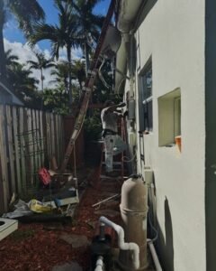 Electrician on a ladder doing exterior wiring in Plattsburgh, NY