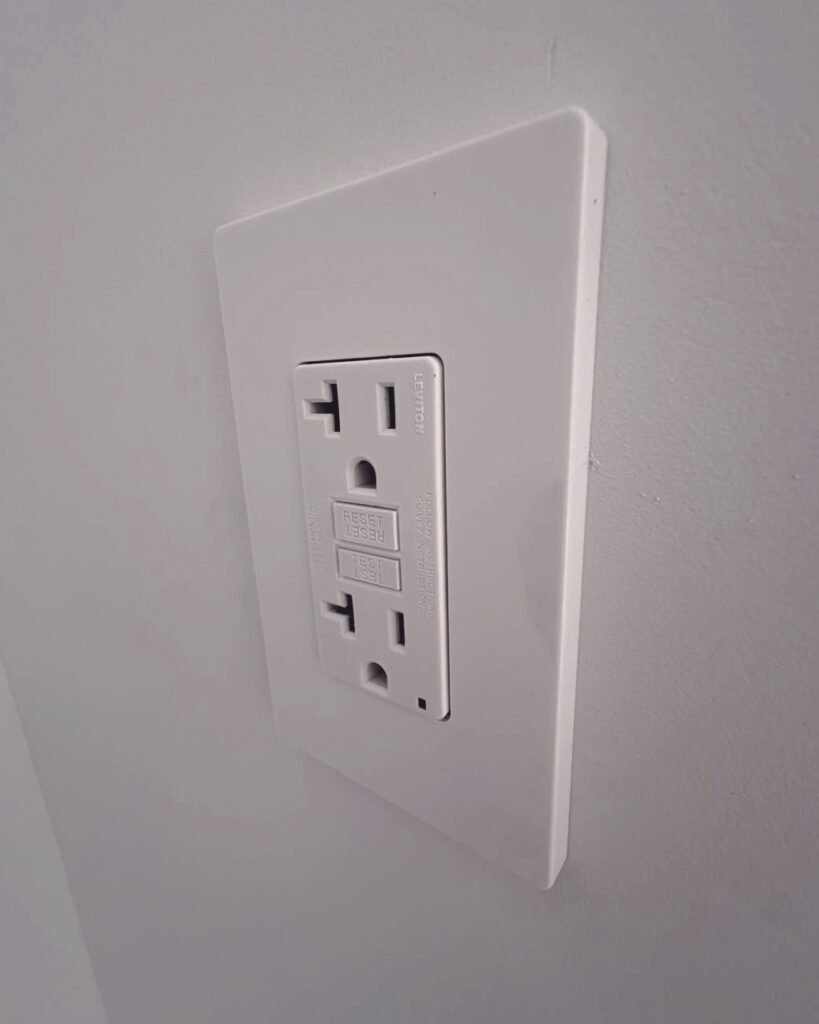 White GFCI outlet and switch plate installed on a wall in Plattsburgh, NY