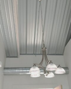 Industrial style chandelier hanging from a metal ceiling in Plattsburgh, NY